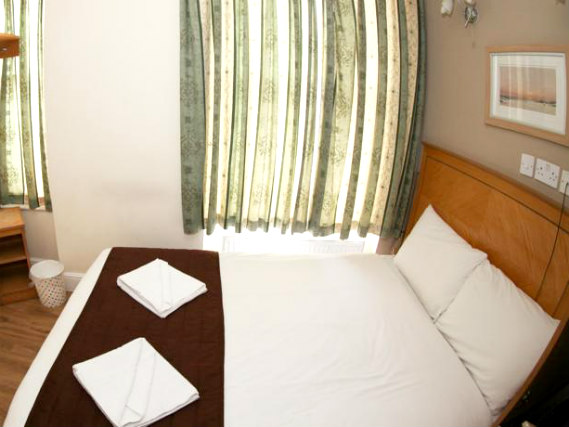 Put your feEin Doppelzimmer im Kensington Suite Hotelet up in front of the TV in your room