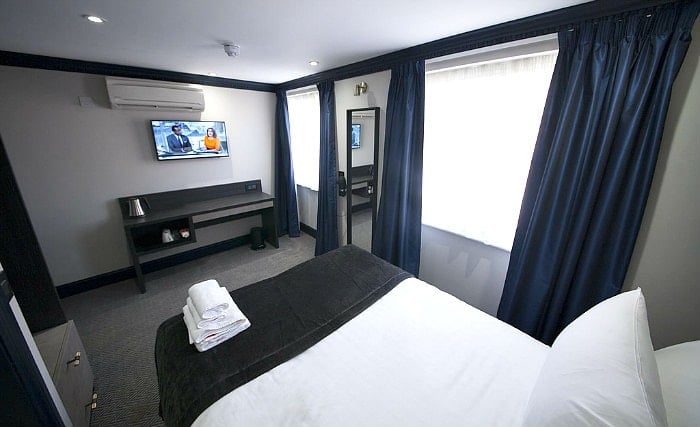 Put your feet up in front of the TV in your room at House of Toby Hotel