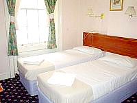 A typical Twin room with private bathroom at Warwick Rooms London