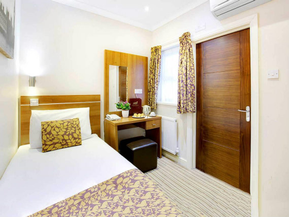 Rest easy in a comfortable bed in your room at Queens Park Hotel