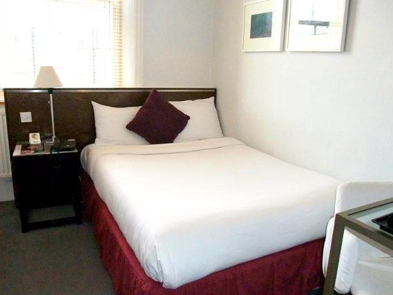 Rest easy in a comfortable bed in your room at Kensington Rooms Hotel