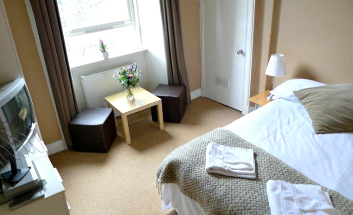 Put your feet up in front of the TV in your room at New Town Apartments